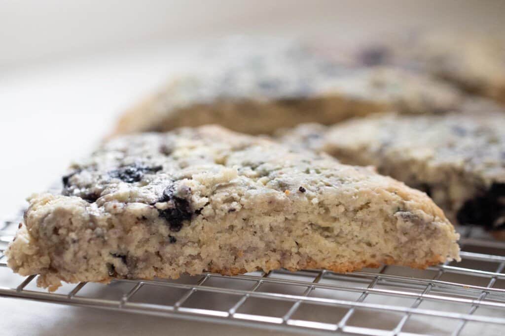 side view of sourdough scones on a wire rack on a white countertop