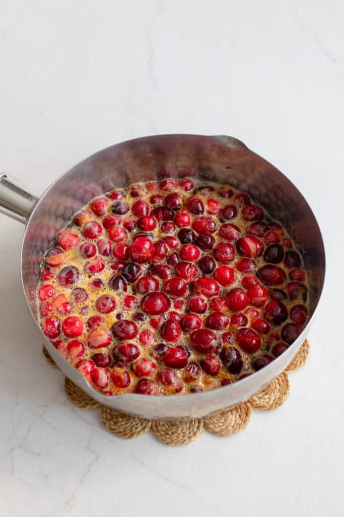 cranberry mixture boiling on the stove until the berries split open.