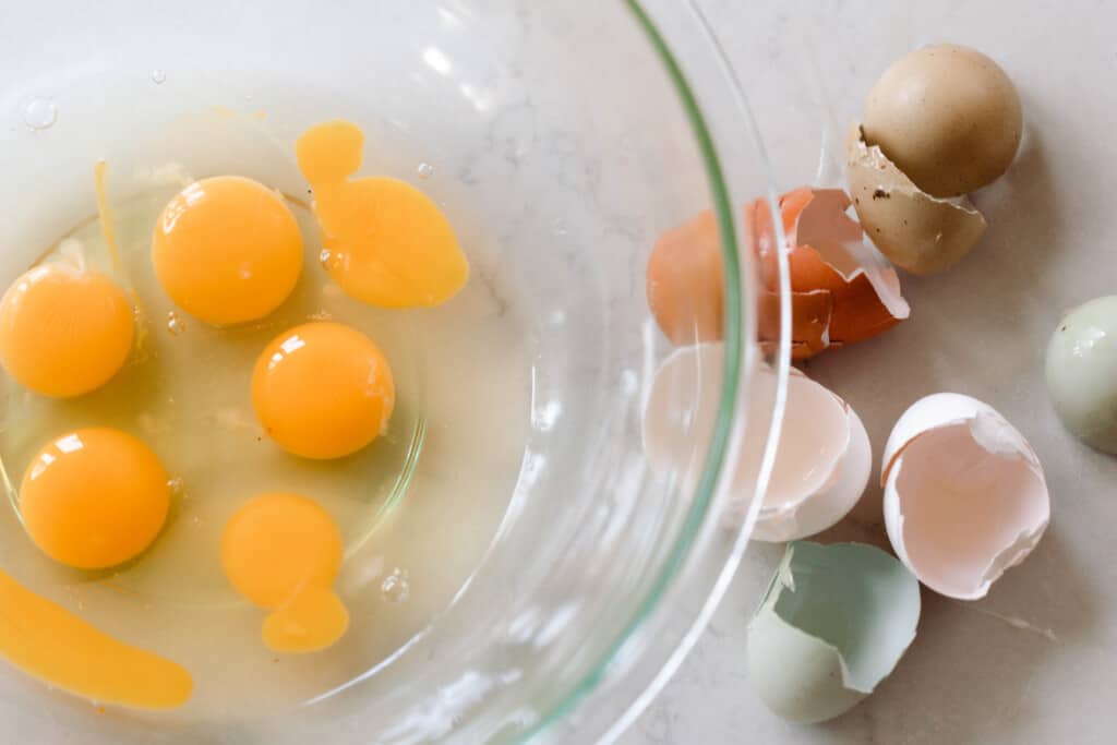 eggs in a glass bowl with eggs shells to the right