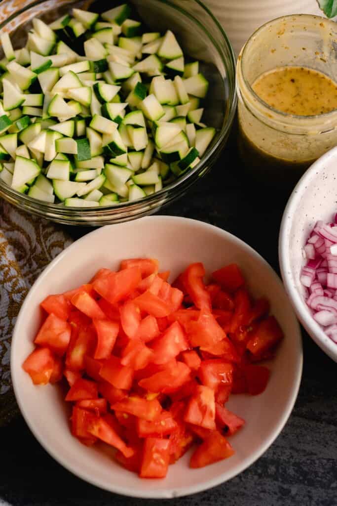 tomatoes, zucchini, and onions chopped and in separate bowls