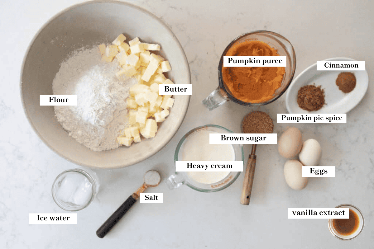 Ingredients for pumpkin pie on a white countertop.