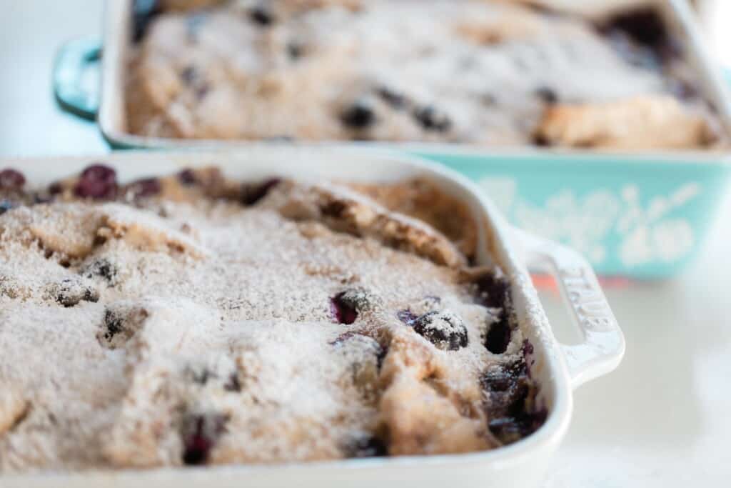 side view of two baking dishes of stuffed French toast casserole with blueberries