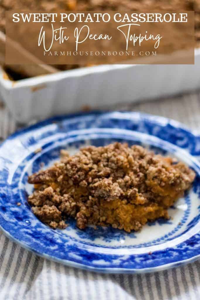 healthy sweet potato casserole with pecan topping on a white and blue plate. The remaining casserole is behind the plate in a white baking dish