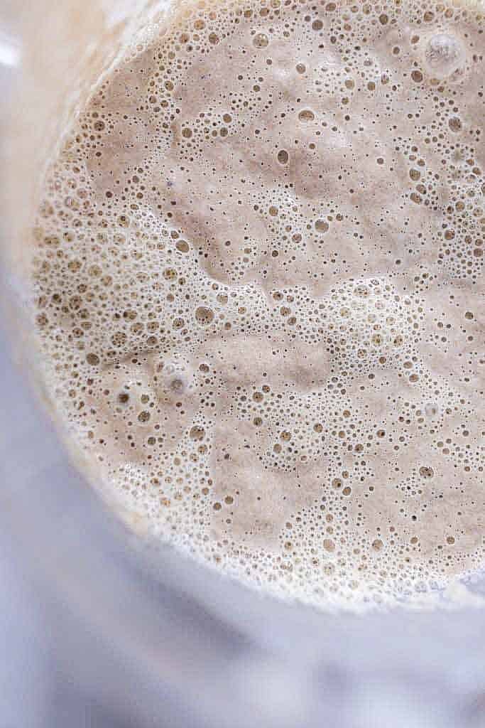 overhead photo of a active, bubbly sourdough starter in a glass bowl