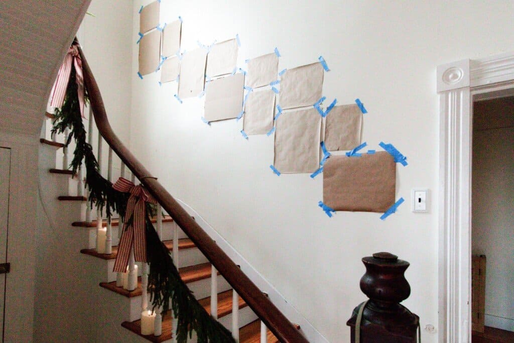 picture frame templates up on a staircase wall with blue painters tape
