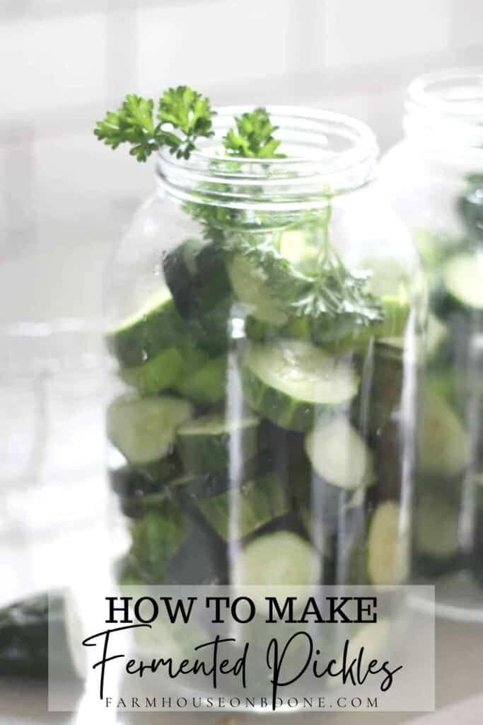 cucumber slices and parsley in a half gallon mason jar on a white countertop with a white backsplash in the background