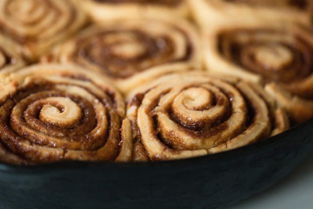 close up picture of einkorn cinnamon rolls in a cast iron skillet