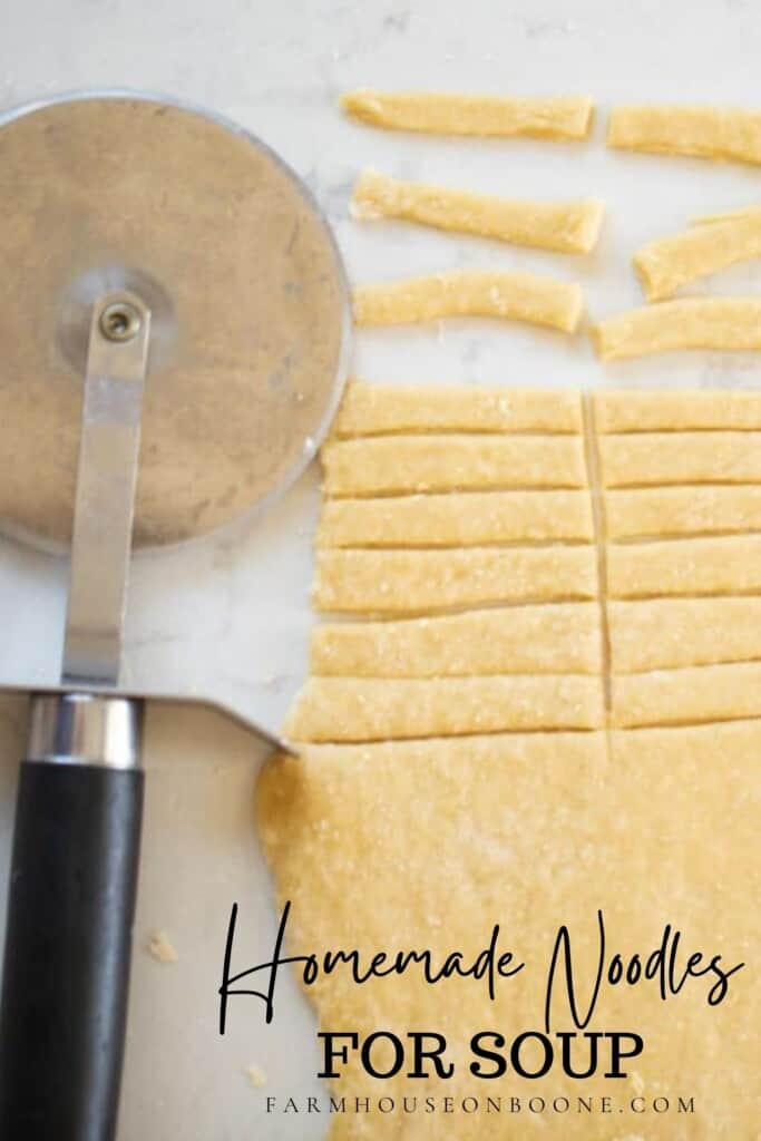 close up picture of homemade noodles rolled out and half the dough is cut into small noodles for soup