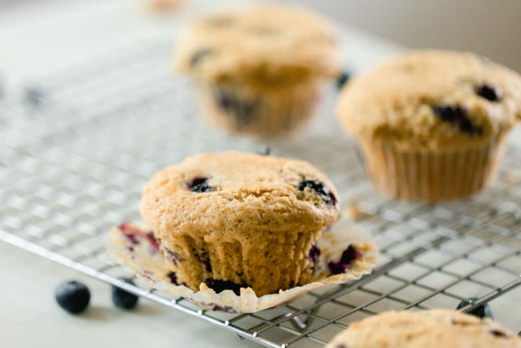 four sourdough blueberry muffins on wire rack