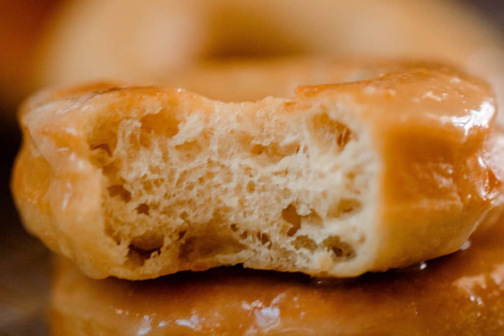 a bite out of a donut with a glaze on top of another donut