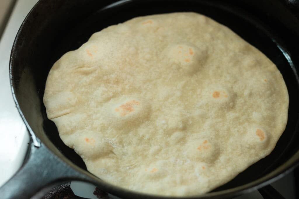 cooking tortillas in a cast iron skillet