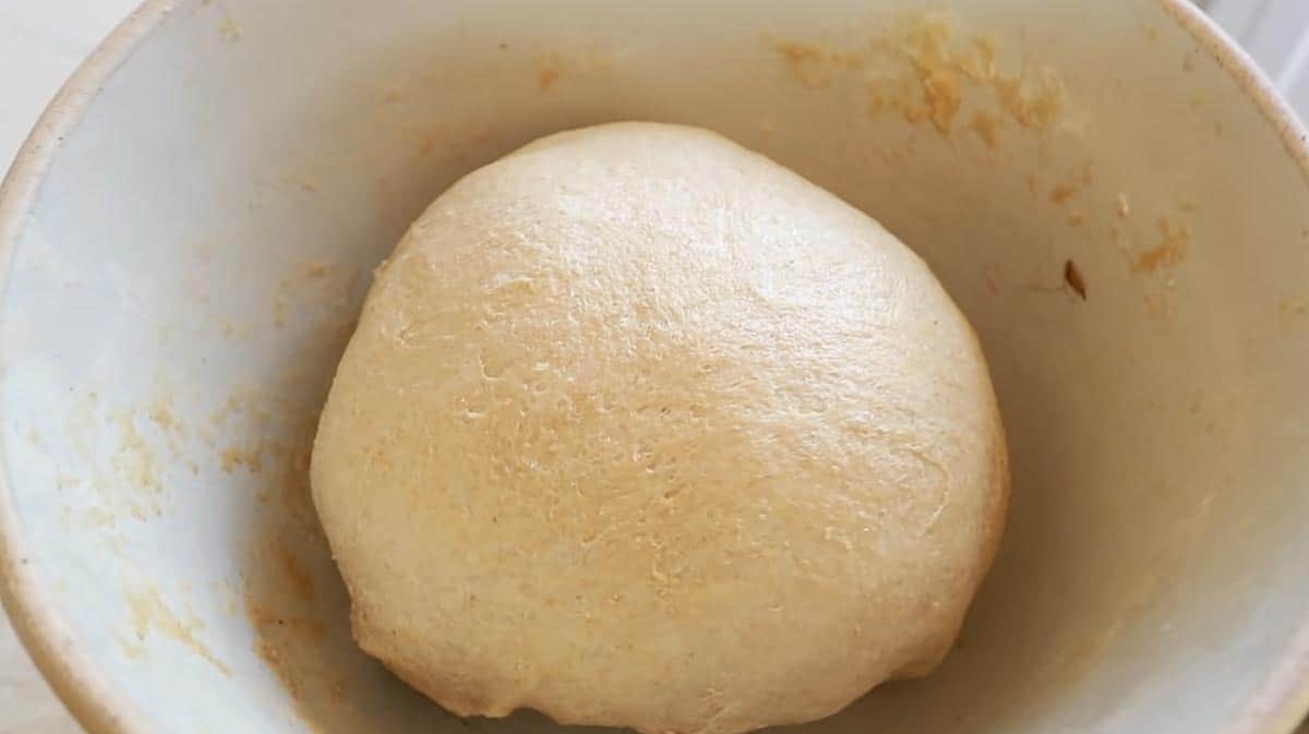 whole wheat sourdough bread dough in a ironstone bowl