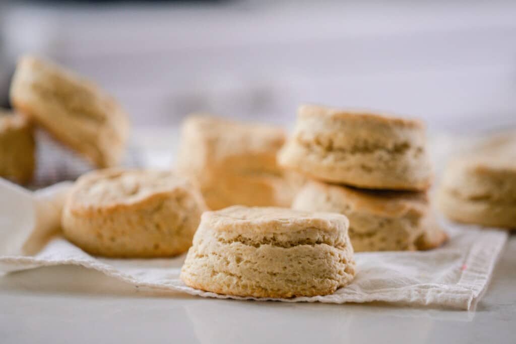 fluffy sourdough biscuits spread out on a cream towel  