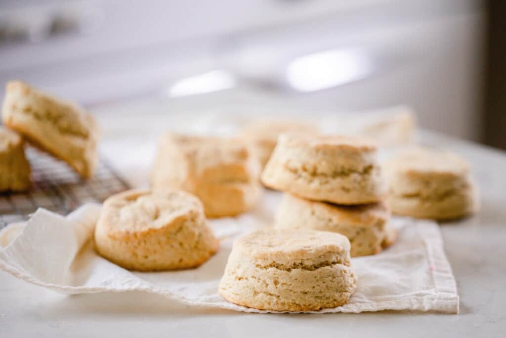 sourdough biscuits cooling on a cream colored towel on a kitchen island with white quartz counters
