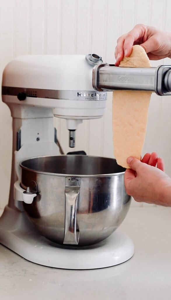 running sourdough pasta dough through a Kitchenaid pasta maker attachment.