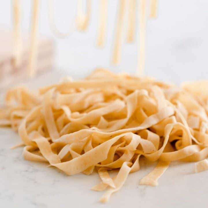 sourdough pasta noodles in a pile on a white and gray quartz countertop