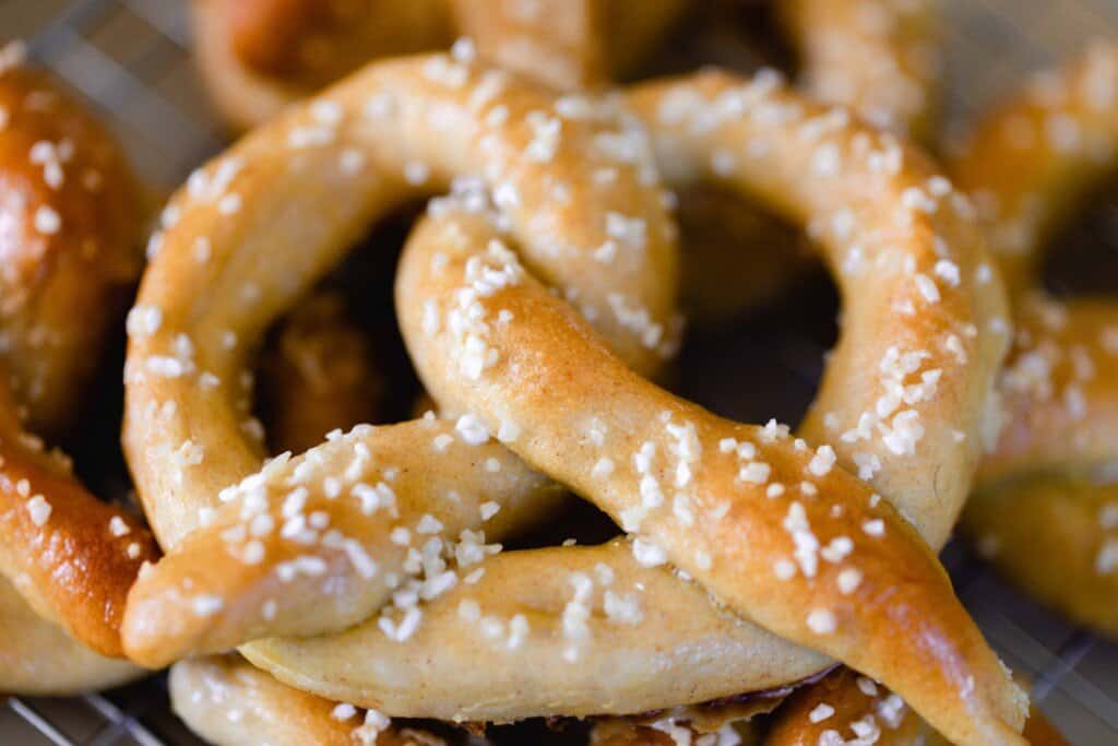 close up picture of a golden sourdough soft pretzel topped with course sea salt