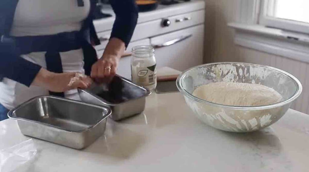 women oiling two stainless steel loaf pans