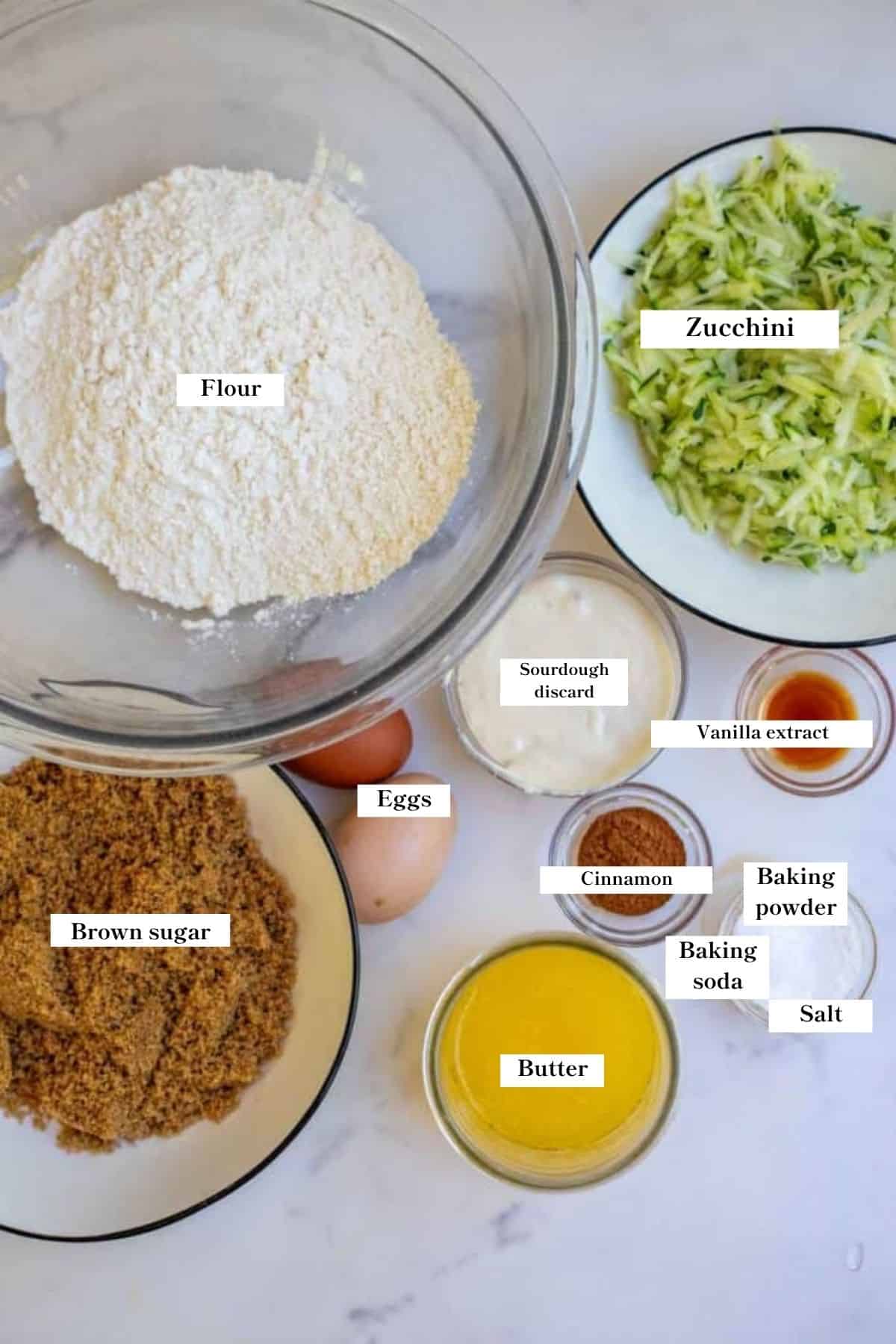 Ingredients for sourdough zucchini bread in bowls on a counter.