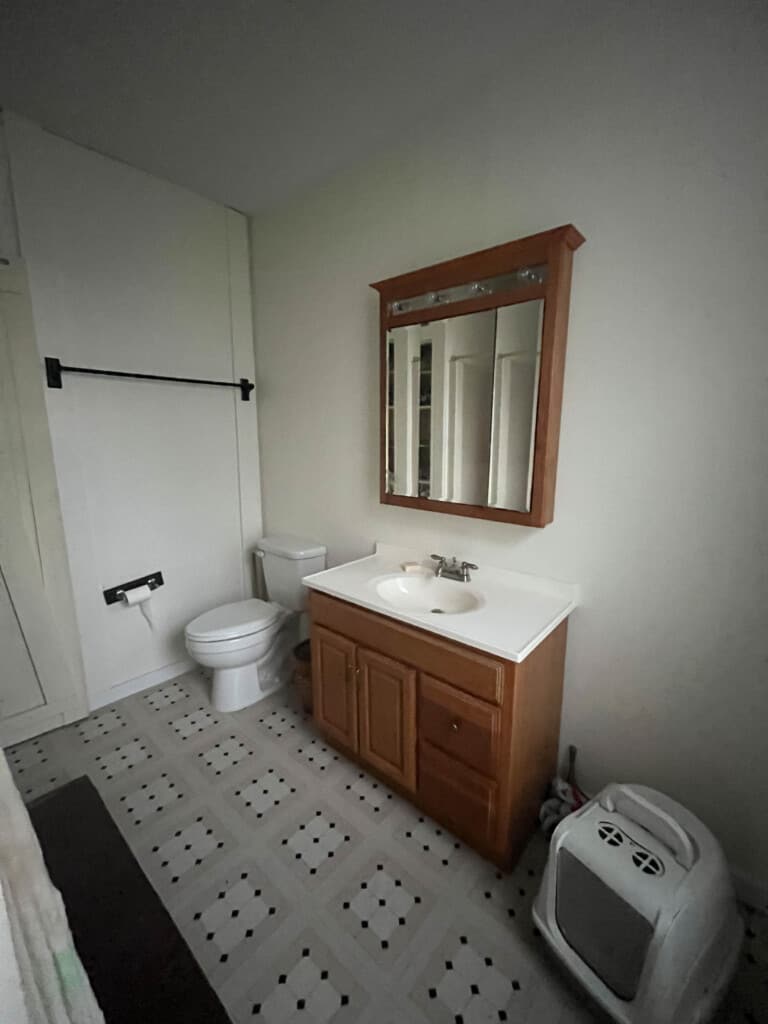 before picture of a outdated bathroom with a 80's vanity with matching medicine cabinet, and linoleum floors