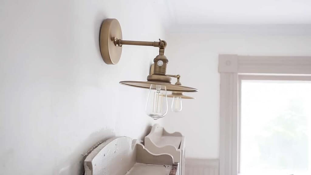 brass vintage inspired lights hanging over antique medicine cabinets