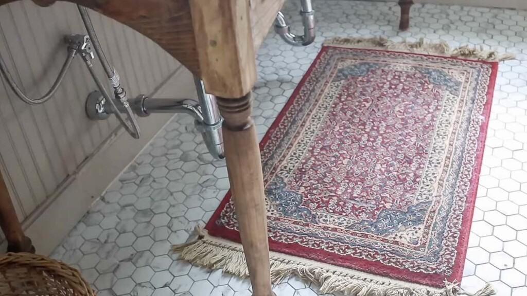 red vintage rug on a marble hexagon floor under a vanity