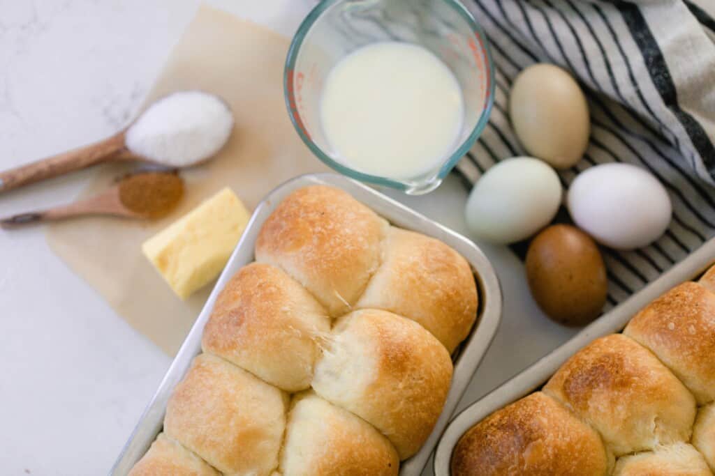 Brioche bread, eggs, milk, sugar, butter, and cinnamon on a countertop