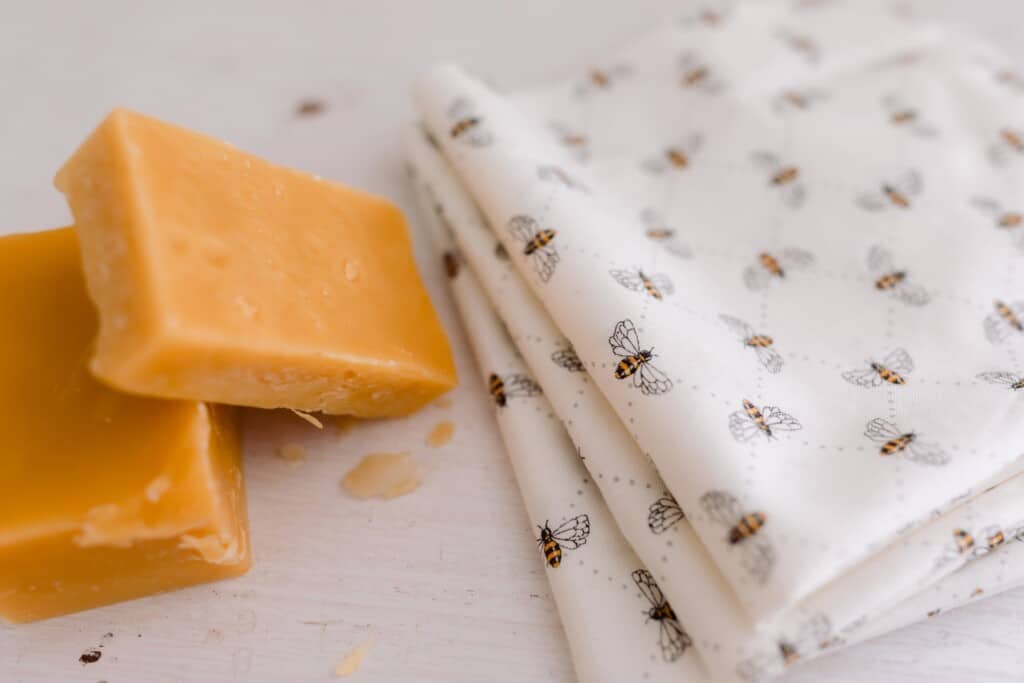 folded bee patterned fabric with chunks of beeswax to the left