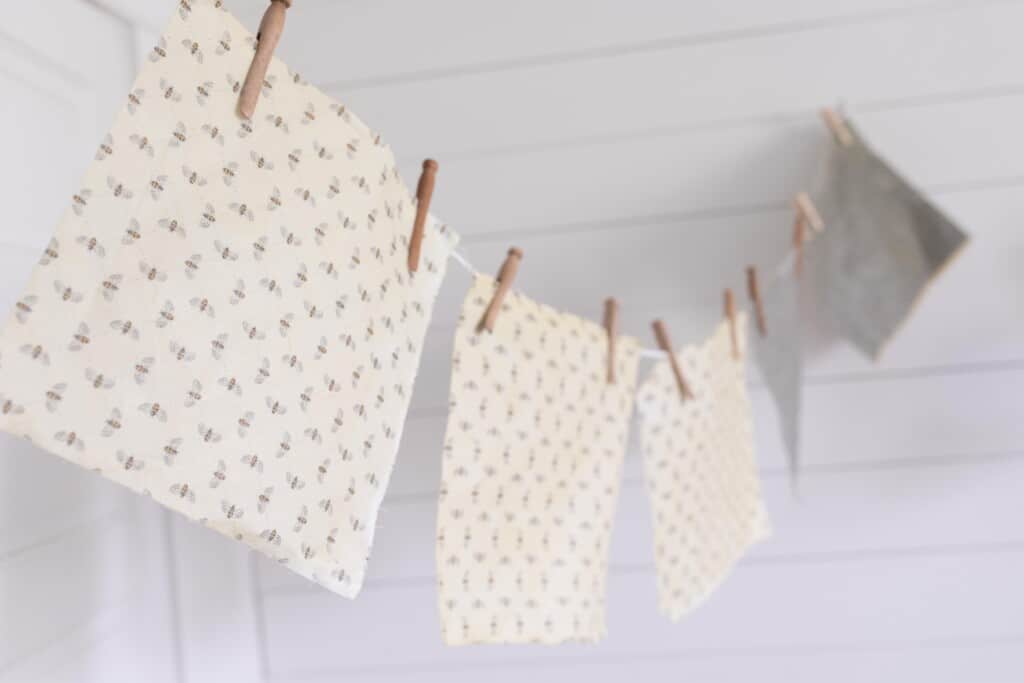 beeswax wraps hanging to dry on a string with clothespins