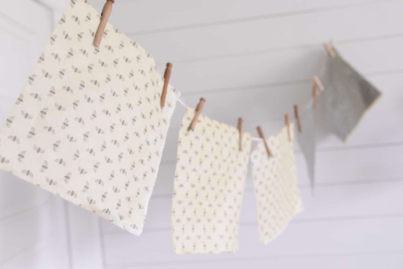 beeswax wraps hanging to dry on a string with clothespins