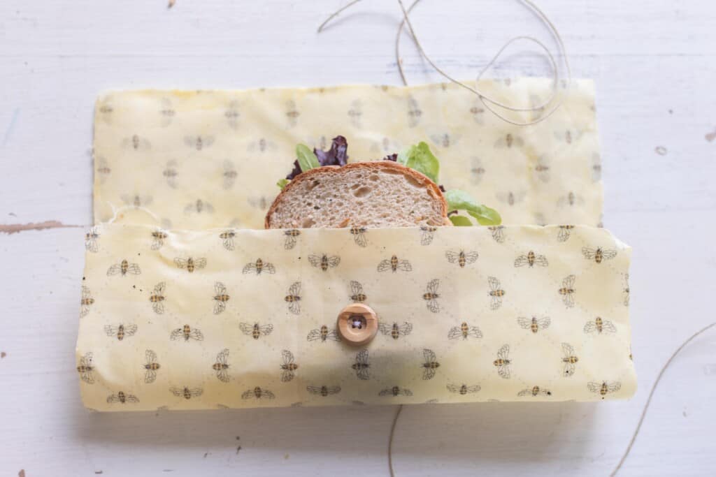 sandwich placed in a beeswax wraps with a button and string