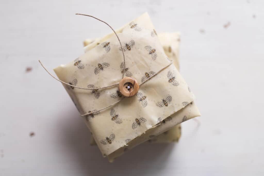 overhead photo of sandwiches wrapped in beeswax wraps with buttons and strings. 