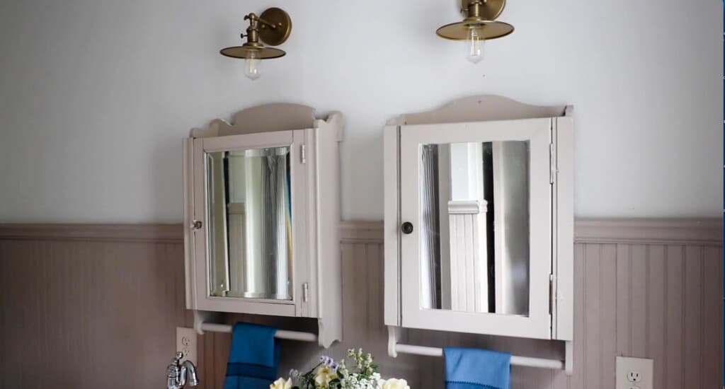 two vintage medicine cabinets painted beige hung on a wall with headboard