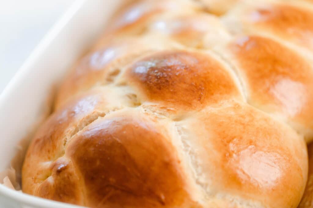 close up photo of a braided sourdough challah with a gorgeous golden crust