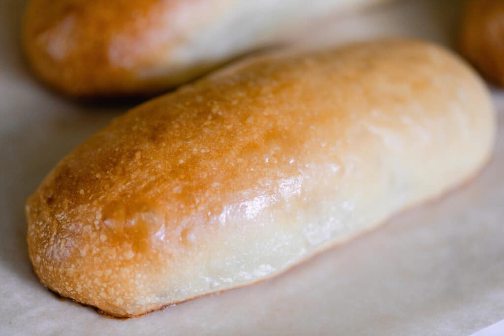 close up picture of golden brown sourdough hot dog buns