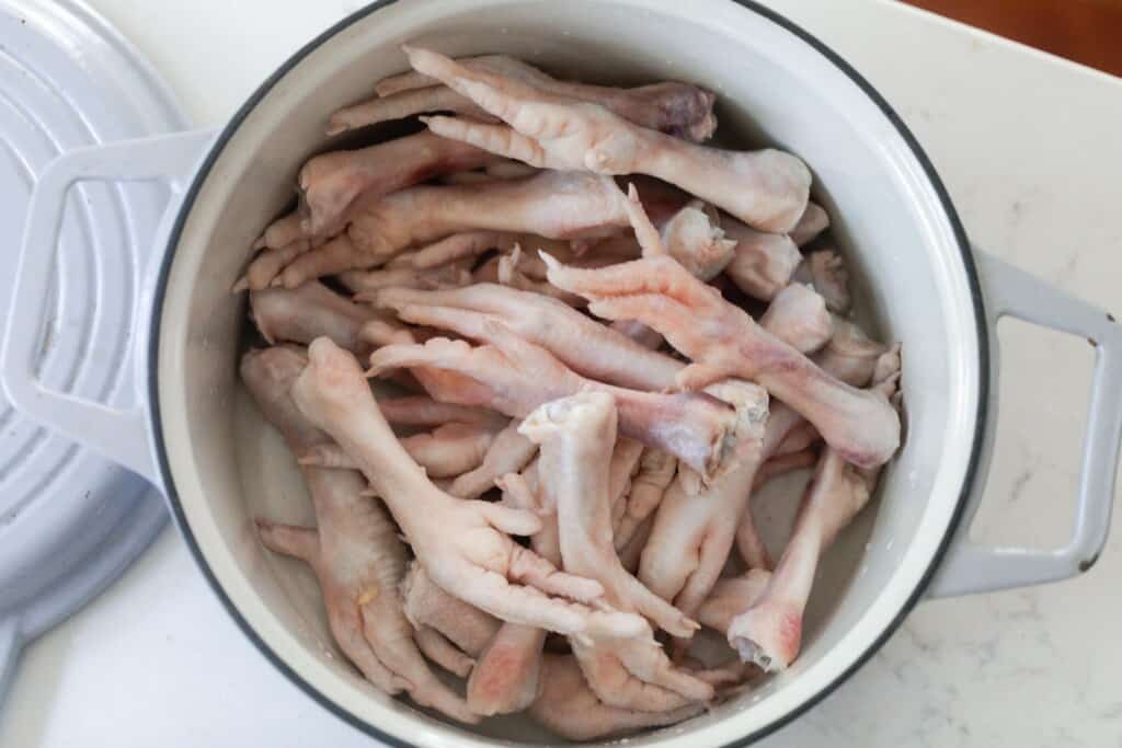 chicken feet in a white dutch oven