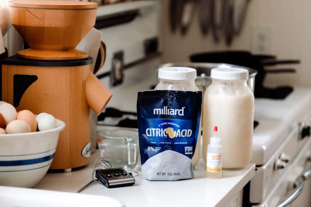 homemade mozzarella ingredients on a white countertop with an antique stove in the background