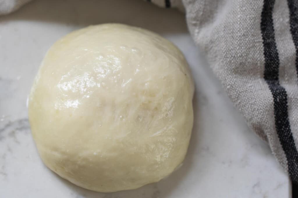 ball of fresh homemade mozzarella cheese on a white countertop