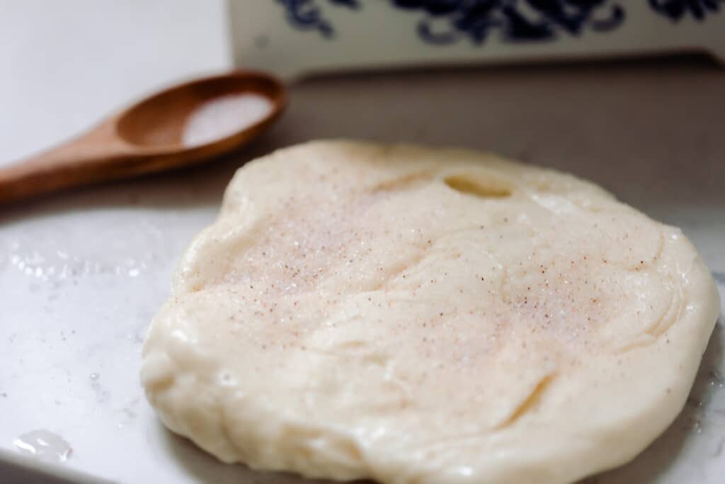 salt sprinkled over homemade mozzarella cheese on a white counter