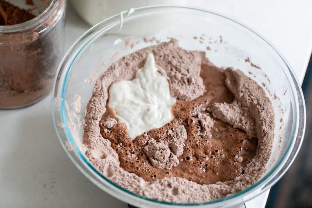 water, sourdough starter, and dry ingredients in a glass bowl