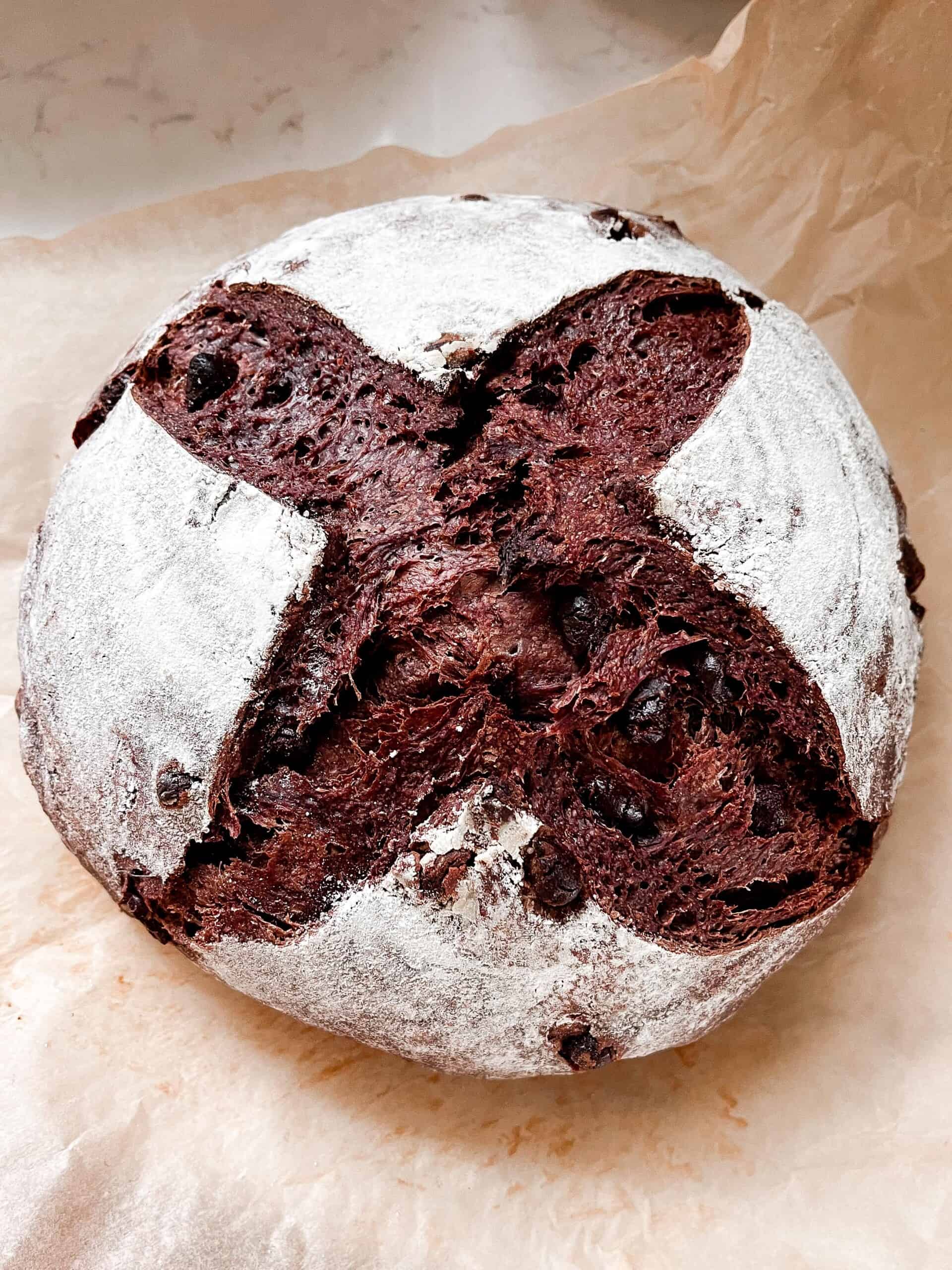 loaf of crust chocolate sourdough bread on parchment paper