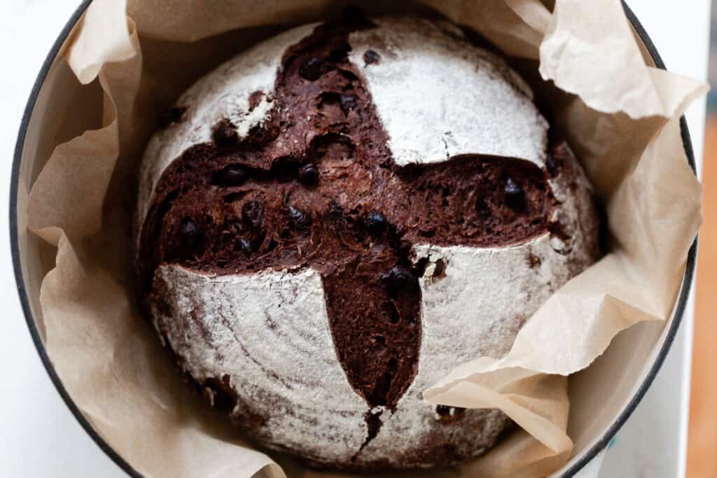 sourdough chocolate bread baked in a dutch oven lined with parchment paper