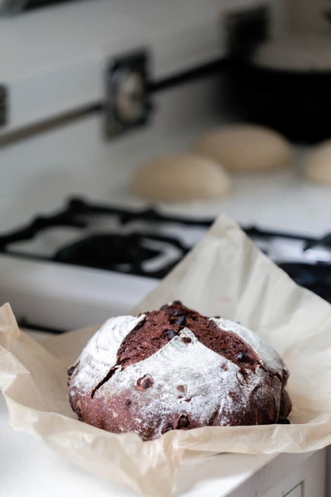 sourdough chocolate bread cooling on parchment paper on the counter