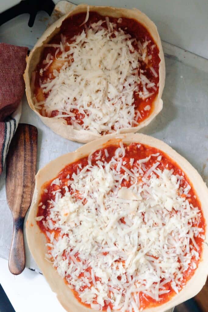 two sourdough pizzas topped with tomato sauce snd cheese