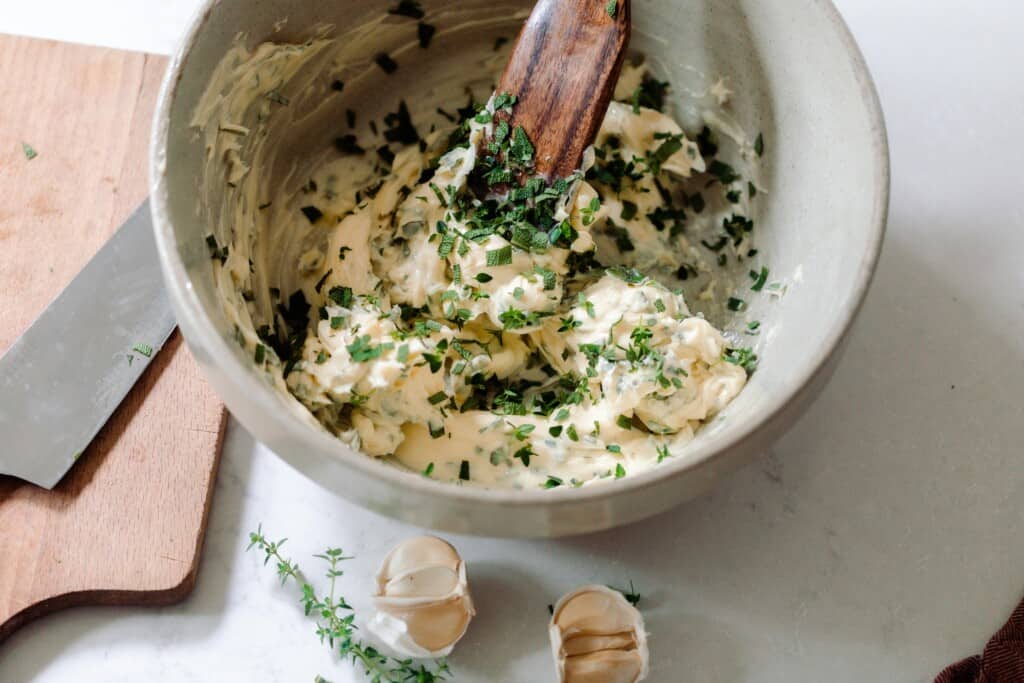 herb butter mixed in a bowl with a wooden spatula