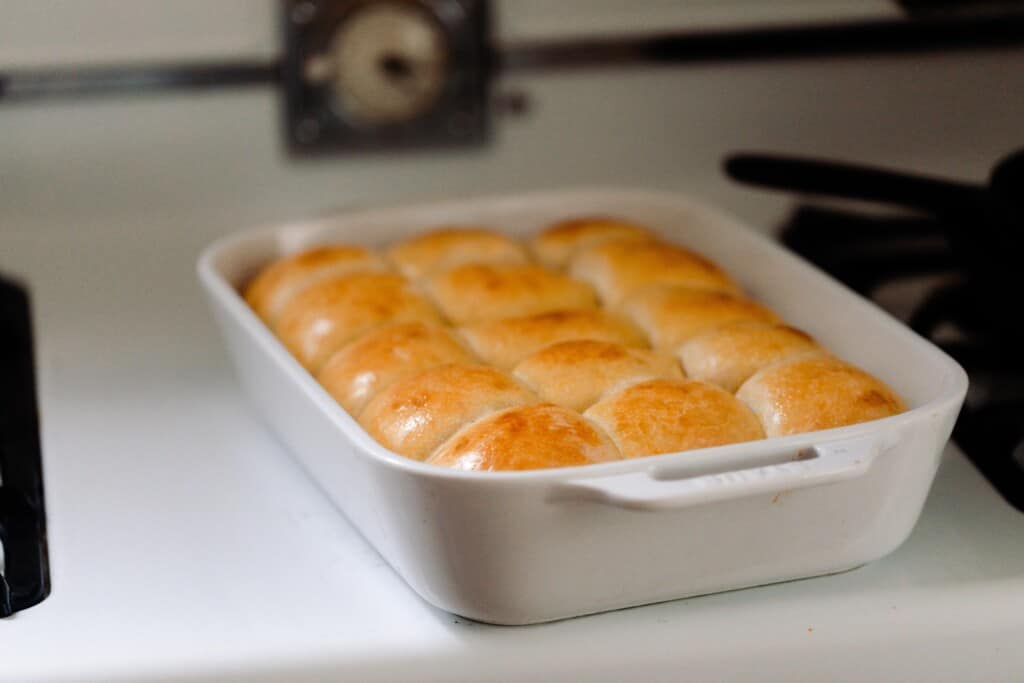 baking dish full of Hawaiian sweet rolls on a vintage stove