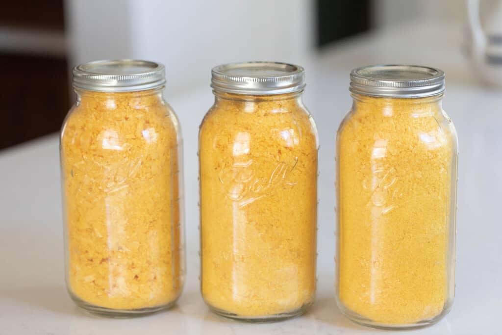 three half gallon mason jars filled with freeze dried eggs. The jars sit on a white countertop