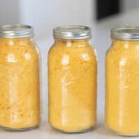 three half gallon mason jars filled with freeze dried eggs. The jars sit on a white countertop
