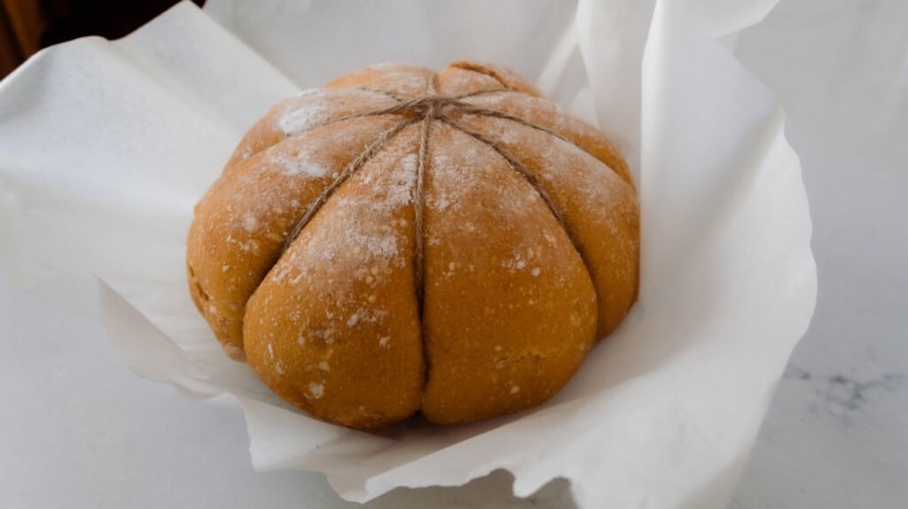 pumpkin shaped bread on parchment paper right out of the oven