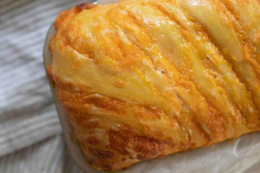 overhead close up photo of sourdough cheese bread with swirls of cheese throughout the loaf